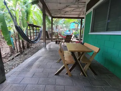 a patio with a table and chairs and a hammock at Hammock plantation in El Zonte