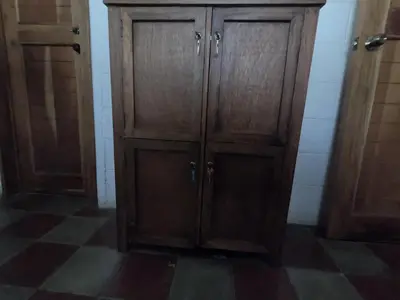 a wooden cabinet in a room with a checkered floor at Hammock plantation in El Zonte