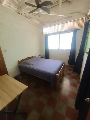 a bedroom with a bed and a ceiling fan at Hammock plantation in El Zonte