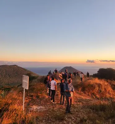a group of people walking on a hill at Hotel Finca Campo Bello in Cerro Verde