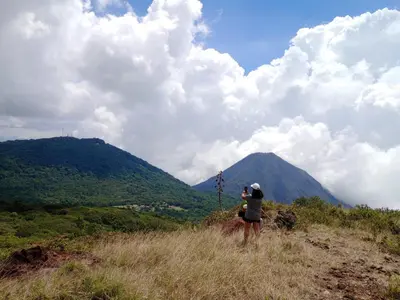 a person standing on a hill looking at a mountain at Hotel Finca Campo Bello in Cerro Verde