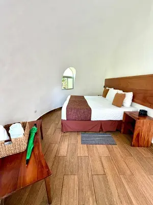 a hotel room with a bed and a table at Hotel Finca Campo Bello in Cerro Verde