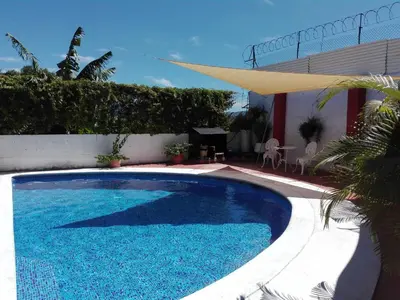 a large blue swimming pool next to a house at Casa San Benito in San Salvador