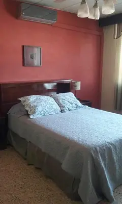 a bedroom with a bed with a red wall at Casa San Benito in San Salvador