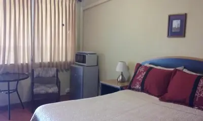 a bedroom with a bed and a table with a microwave at Casa San Benito in San Salvador
