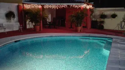 a large swimming pool in a yard with lights at Casa San Benito in San Salvador