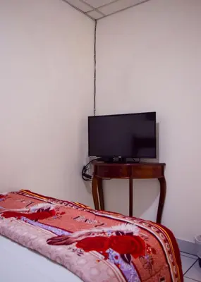 a bedroom with a bed and a tv on a table at Hotel San José de la Montaña in San Salvador
