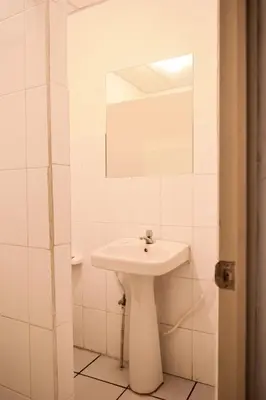 a white bathroom with a sink and a mirror at Hotel San José de la Montaña in San Salvador