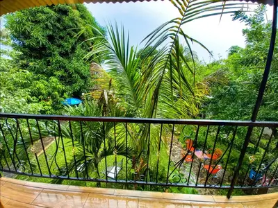 a balcony with a view of a garden at Hostal Koltin Suchitoto in Suchitoto