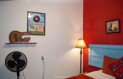 a bedroom with a fan and a red wall at Hostal Koltin Suchitoto in Suchitoto
