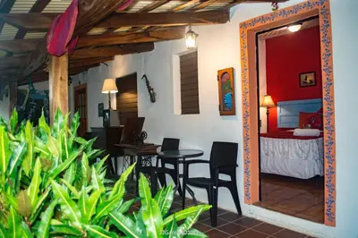 a room with a bedroom and a table and chairs at Hostal Koltin Suchitoto in Suchitoto