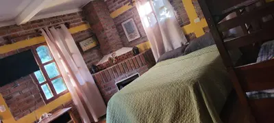 a bedroom with a bed and a brick wall at HOSTAL CABAÑAS AVE MARIA in Concepción de Ataco