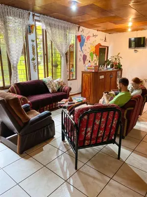 two men are sitting in a living room at Hostal Doña Mercedes in Juayúa