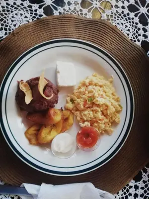a plate of food with scrambled eggs and other foods at Hostal Doña Mercedes in Juayúa