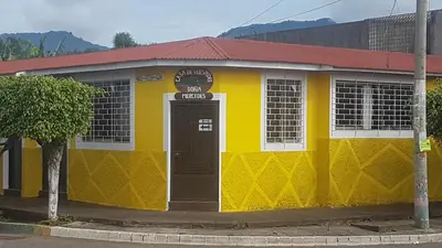 a yellow and white building with a red roof at Hostal Doña Mercedes in Juayúa