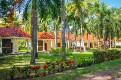 a row of houses with palm trees and flowers at Pato Canales Hotel & Resort in San Luis