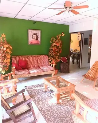 a living room with a red couch and a green wall at Hostal Doña Marta in San Salvador