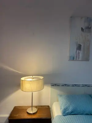 a lamp on a table next to a bed at Velvet Hostal La novena in Santa Ana