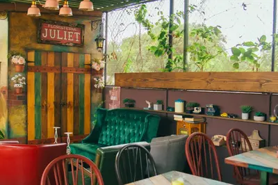a restaurant with a green bench and tables and chairs at Velvet Hostal La novena in Santa Ana
