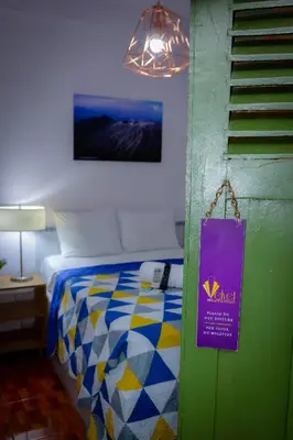 a bedroom with a bed with a purple sign on it at Velvet Hostal La novena in Santa Ana