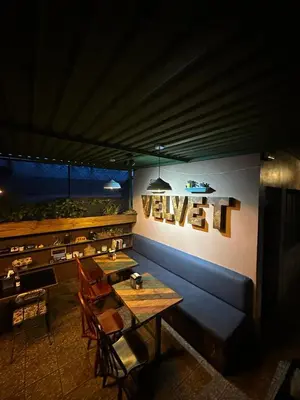 a dining room with a table and chairs and a wall at Velvet Hostal La novena in Santa Ana