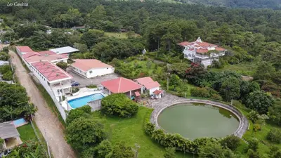 an aerial view of a large house with a pond at Las Tilapias Hotel in San Ignacio