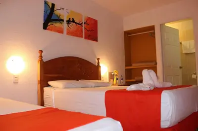 a bedroom with two beds and a mirror at Las Tilapias Hotel in San Ignacio