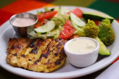 a plate of food with meat and vegetables on a table at Las Tilapias Hotel in San Ignacio