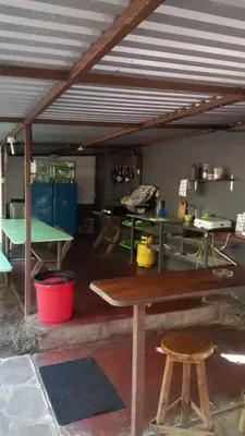 a kitchen with a table and tables in a room at Hostal El Balsamo in El Sunzal