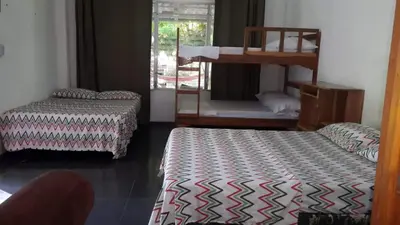 a room with two beds and a bunk bed at Hostal El Balsamo in El Sunzal