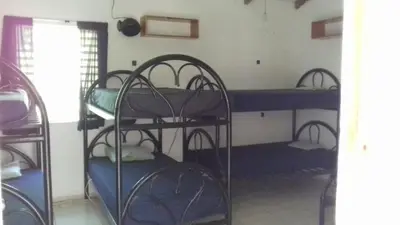 a room with three bunk beds in a room at Hostal El Balsamo in El Sunzal