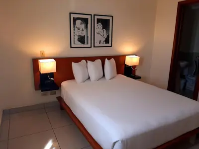 a bedroom with a large white bed with two lamps at Comfort Inn Real San Miguel in San Miguel