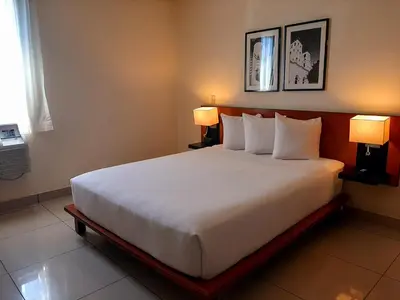 a large bed in a hotel room with two lamps at Comfort Inn Real San Miguel in San Miguel