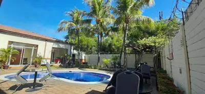 a backyard with a swimming pool and palm trees at Comfort Inn Real San Miguel in San Miguel