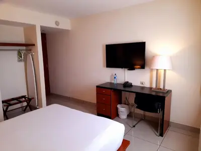 a bedroom with a bed and a desk with a television at Comfort Inn Real San Miguel in San Miguel