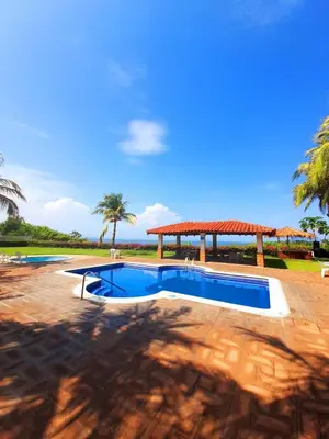 a pool with a gazebo and palm trees at Comfort Inn Real La Union in La Unión