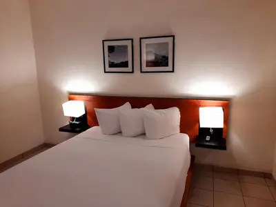 a bedroom with a bed with two lamps on it at Comfort Inn Real La Union in La Unión