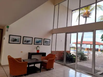 a lobby with chairs and a table and windows at Comfort Inn Real La Union in La Unión