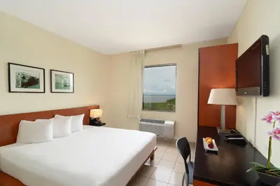a hotel room with a bed and a television at Comfort Inn Real La Union in La Unión