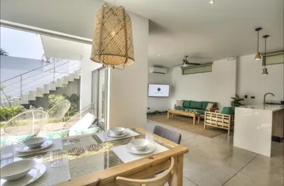 a dining room and living room with a table at Garten Hotel in El Zonte