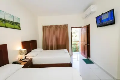 a hotel room with two beds and a flat screen tv at Hotel Mediterraneo Inn in Santa Rosa de Lima