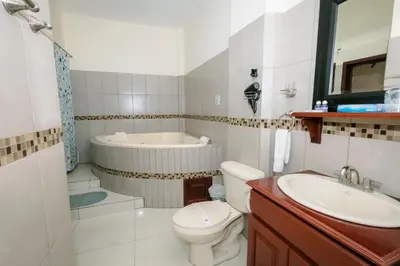 a bathroom with a tub and a toilet and a sink at Hotel Mediterraneo Inn in Santa Rosa de Lima