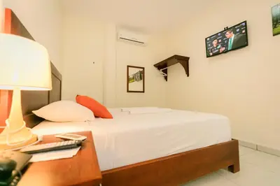 a bedroom with a bed and a table with a lamp at Hotel Mediterraneo Inn in Santa Rosa de Lima