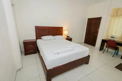 a bedroom with a bed with a wooden headboard at Hotel Mediterraneo Inn in Santa Rosa de Lima