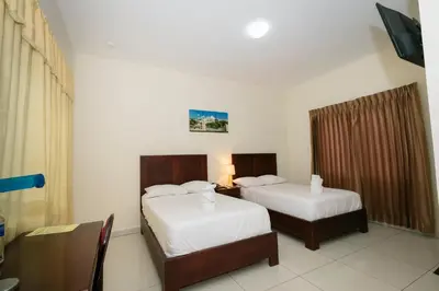 a hotel room with two beds and a television at Hotel Mediterraneo Inn in Santa Rosa de Lima