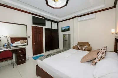 a bedroom with a bed and a desk and a mirror at Hotel Mediterraneo Inn in Santa Rosa de Lima
