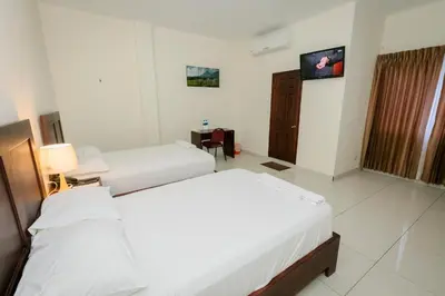 a hotel room with two beds and a television at Hotel Mediterraneo Inn in Santa Rosa de Lima