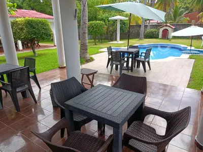 a patio with tables and chairs and a pool at Rancho villas de alicia in La Paz
