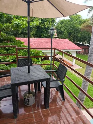 a table and chairs with an umbrella on a deck at Rancho villas de alicia in La Paz