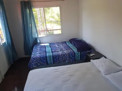 a small bedroom with two beds and a window at Rancho villas de alicia in La Paz